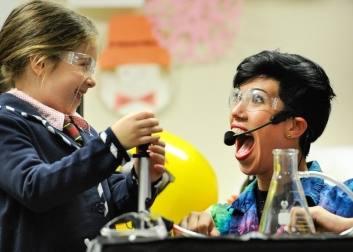 Young girl and woman scientist performing experiment