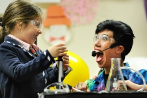 Young girl and woman scientist performing experiment
